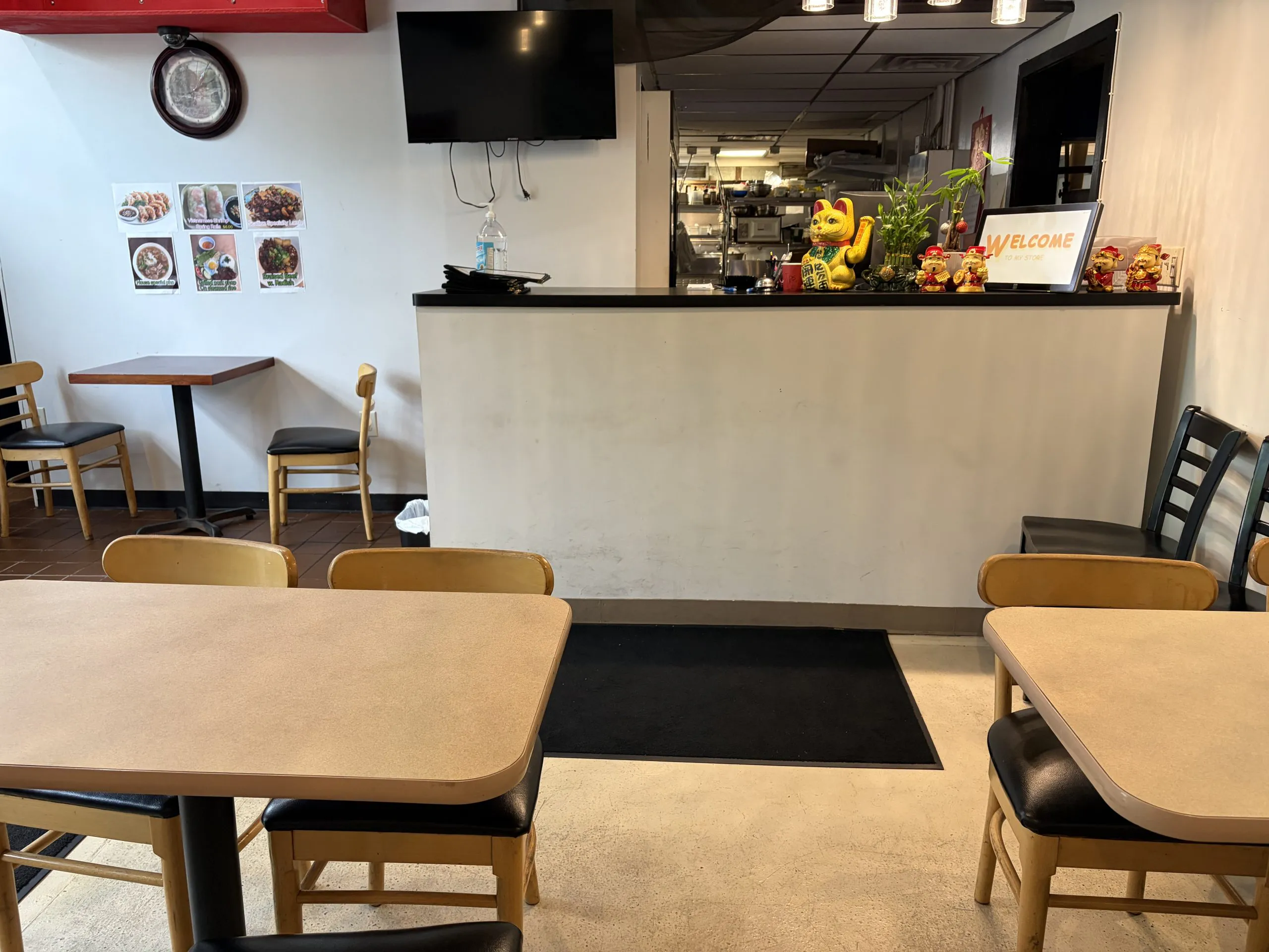 Bright indoor dining room with wooden tables and counter service station at The Wok, an Asian Fusion Restaurant in Rochester