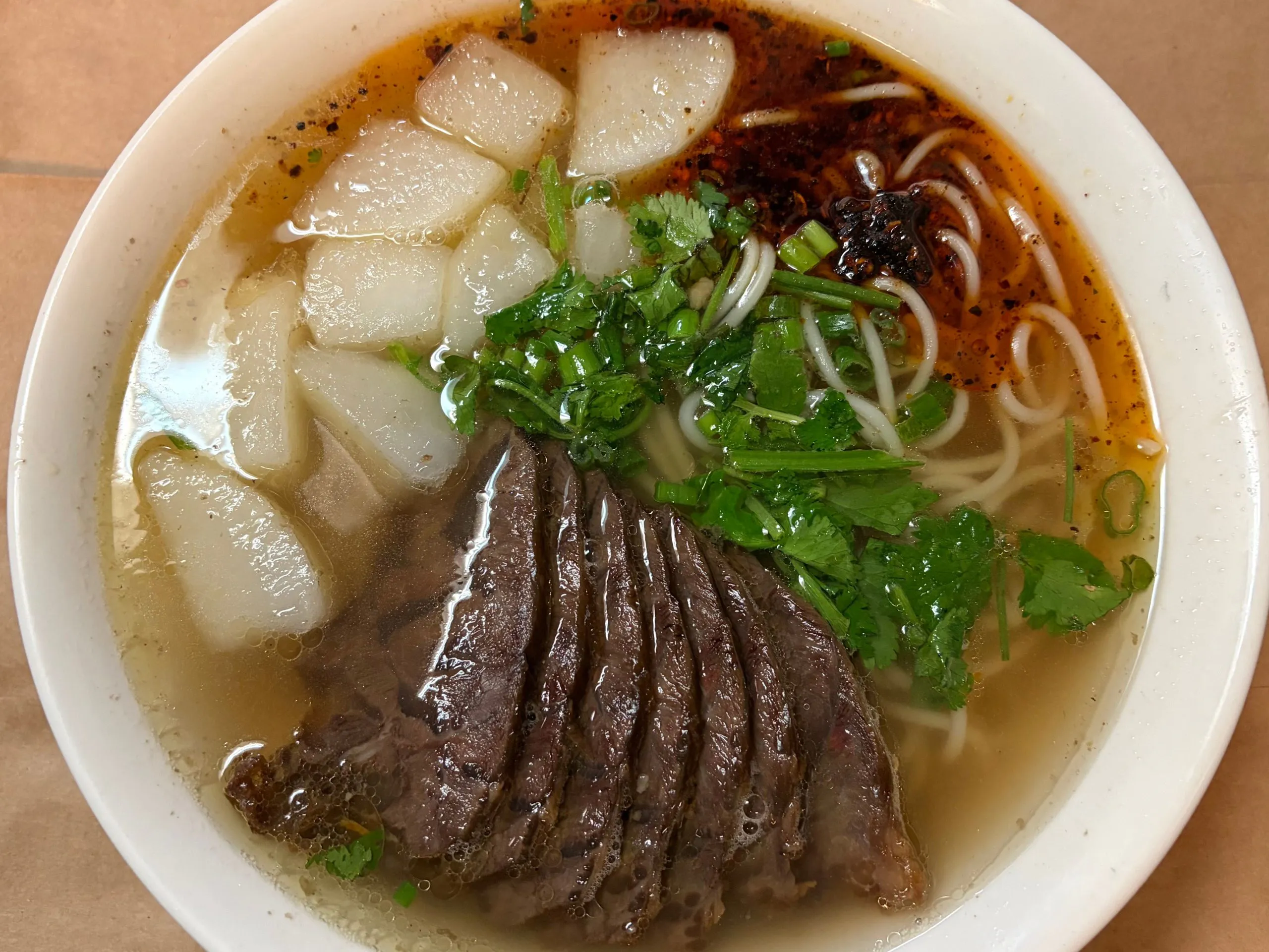 Lanzhou beef noodle soup with tender sliced beef, radish and chopped green onions at The Wok, an Asian Fusion Restaurant in Rochester